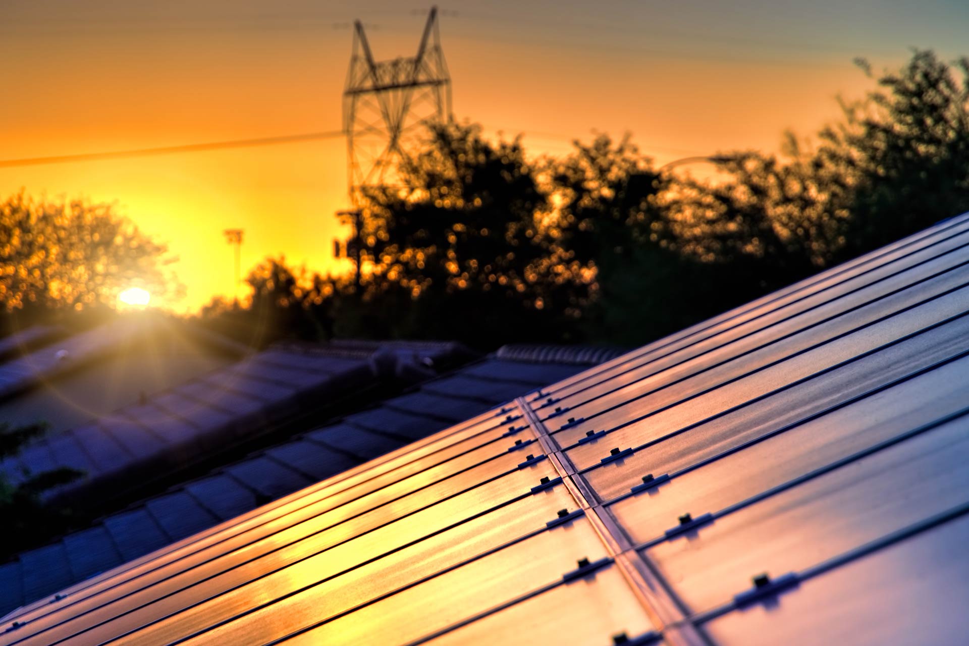 Sonnenuntergang über Solarpanelen auf einem Dach mit angeschlossenem BESS-System